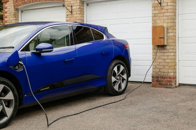How to Extend the Life of Your EV Battery A blue electric vehicle charging at a home charging station