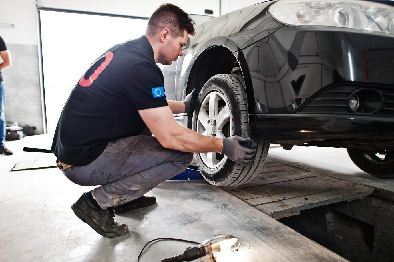 Mechanic in Uniform Inspecting Tyres