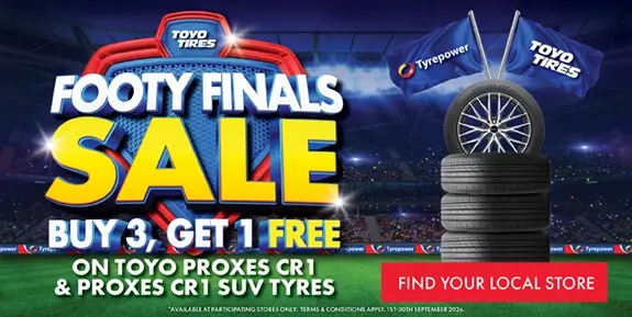 Promo image for a buy 3 get 1 free tyre sale with stack of tyres on an AFL ground.